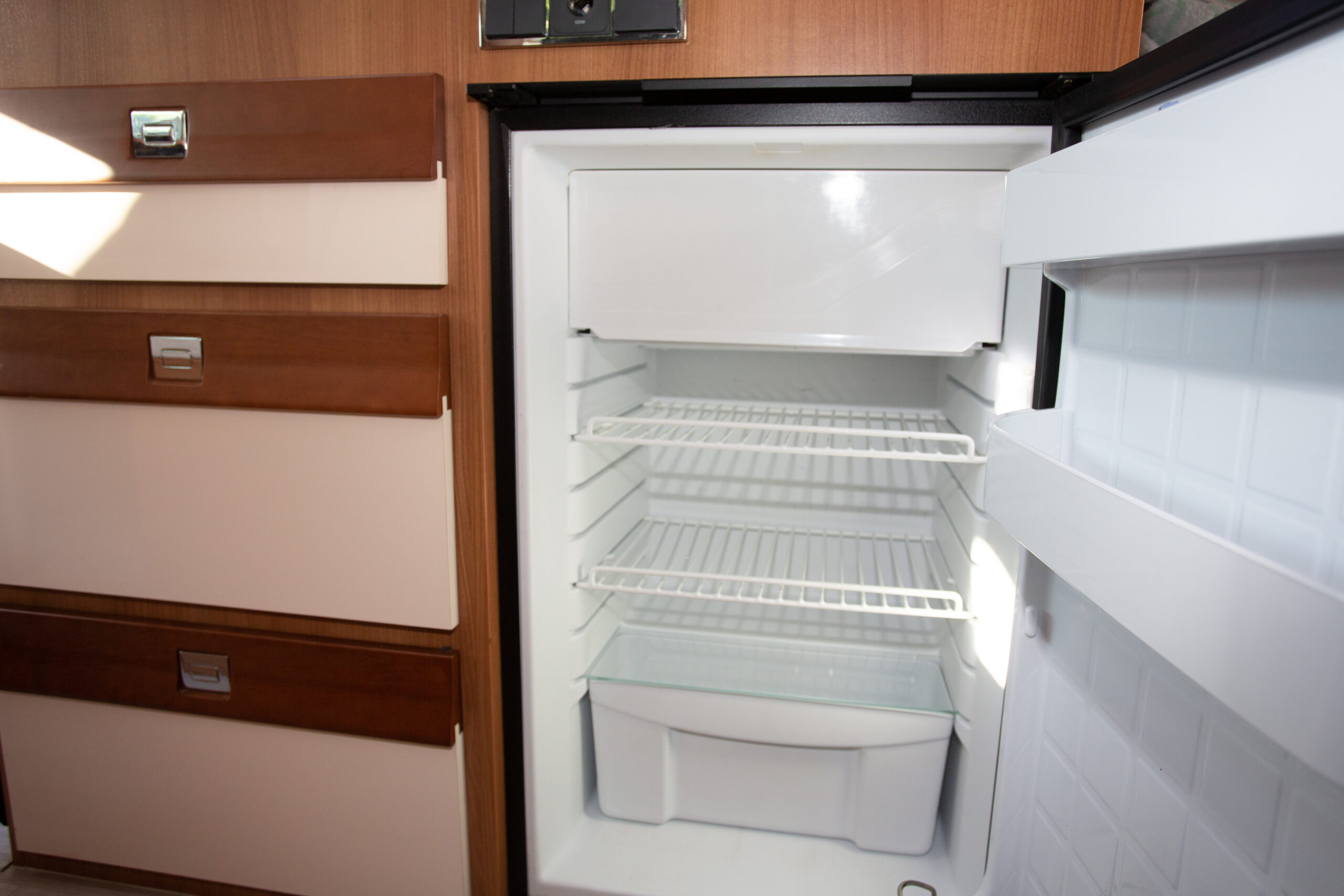 rv open empty fridge in camper van